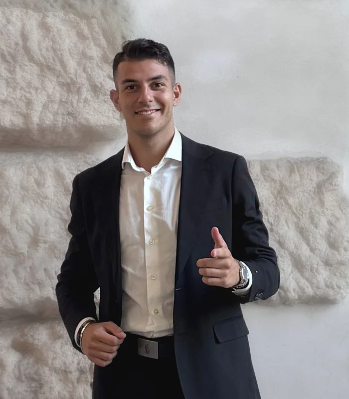 Riccardo Dell'Orletta sorride davanti a un muro in pietra
